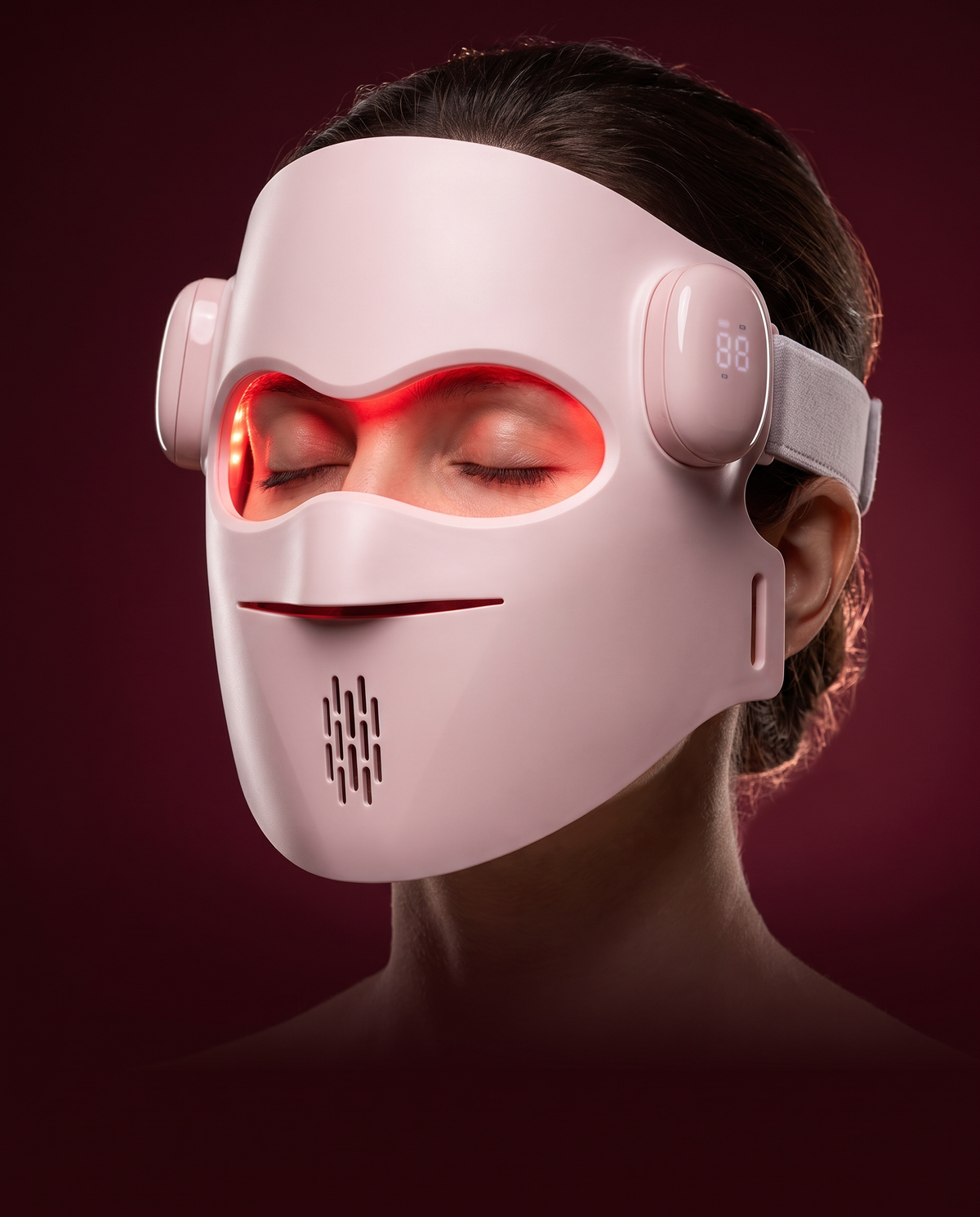 Femme portant le masque LED Zenoza allumé, sur fond bordeaux