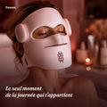 Femme détendue dans son bain portant le masque LED Zenoza, bougies en arrière-plan